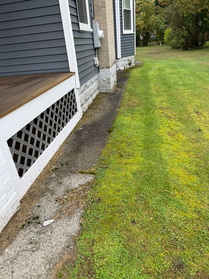 Concrete walkway along the porch, stained and dark