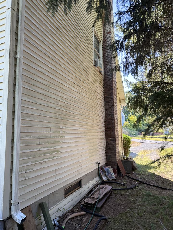 Long side wall with green streaks across the siding
